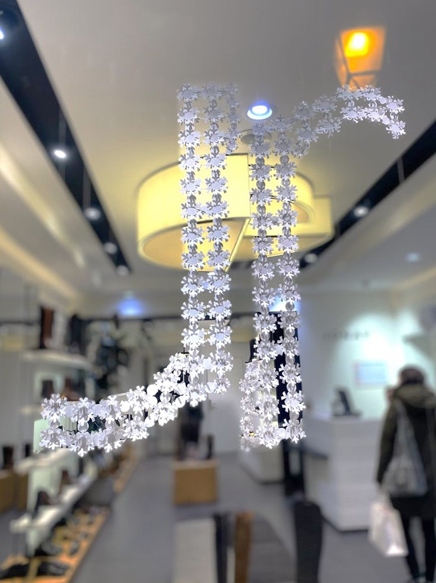 Scénographie de papier pour le Noel de Jonak 2023, Logo Jonak en Flocons de papier découpés acumulés et suspendus, création Laure Devenelle